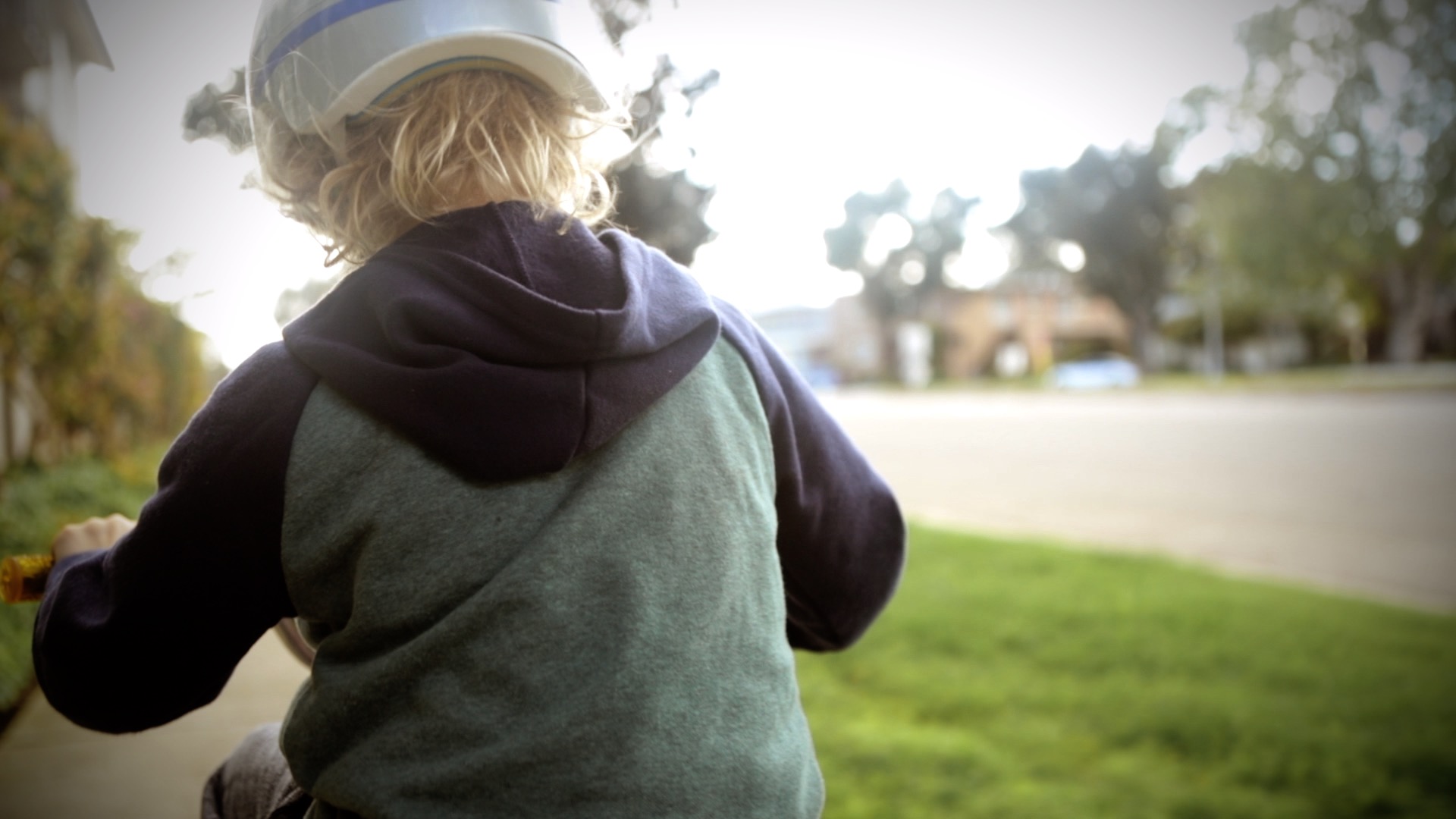 a boy's back while he is riding his bike