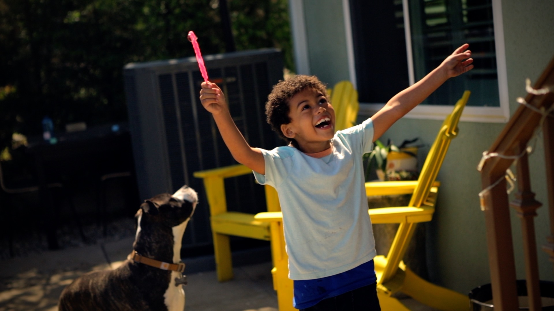 a boy smiling with his arms up